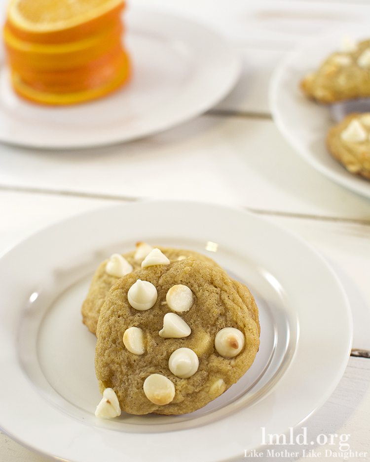 Top view of creamsicle cookies stacked on a white plate.