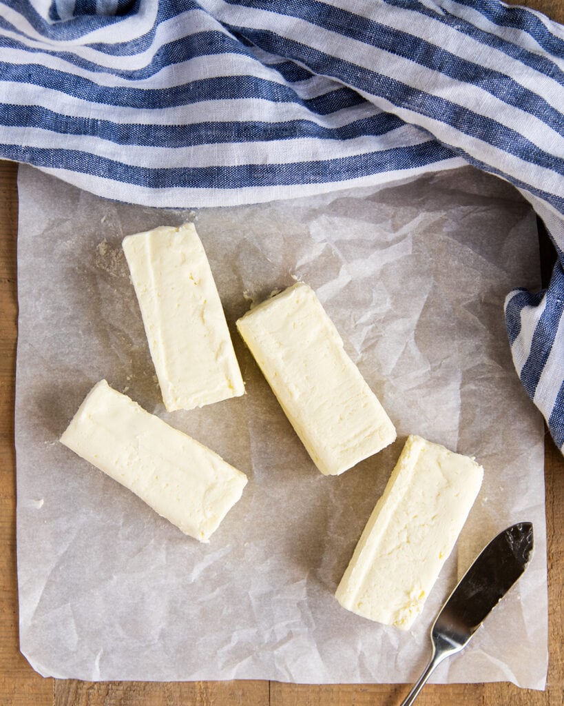 An above photo of four sticks of butter on parchment paper.