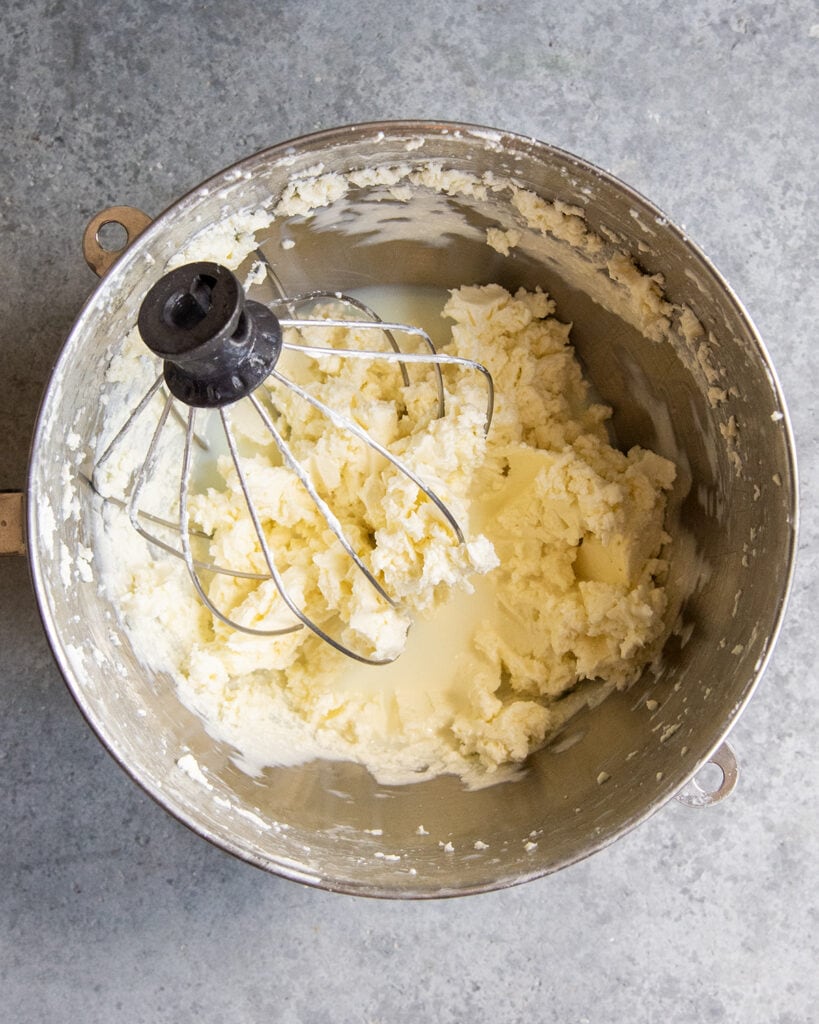 A bowl of butter and buttermilk with a stand mixer whisk in the bowl. 