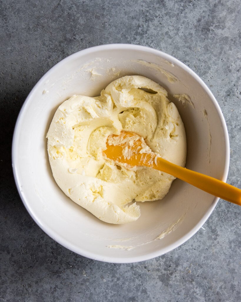 A bowl of softened butter with a rubber spatula.