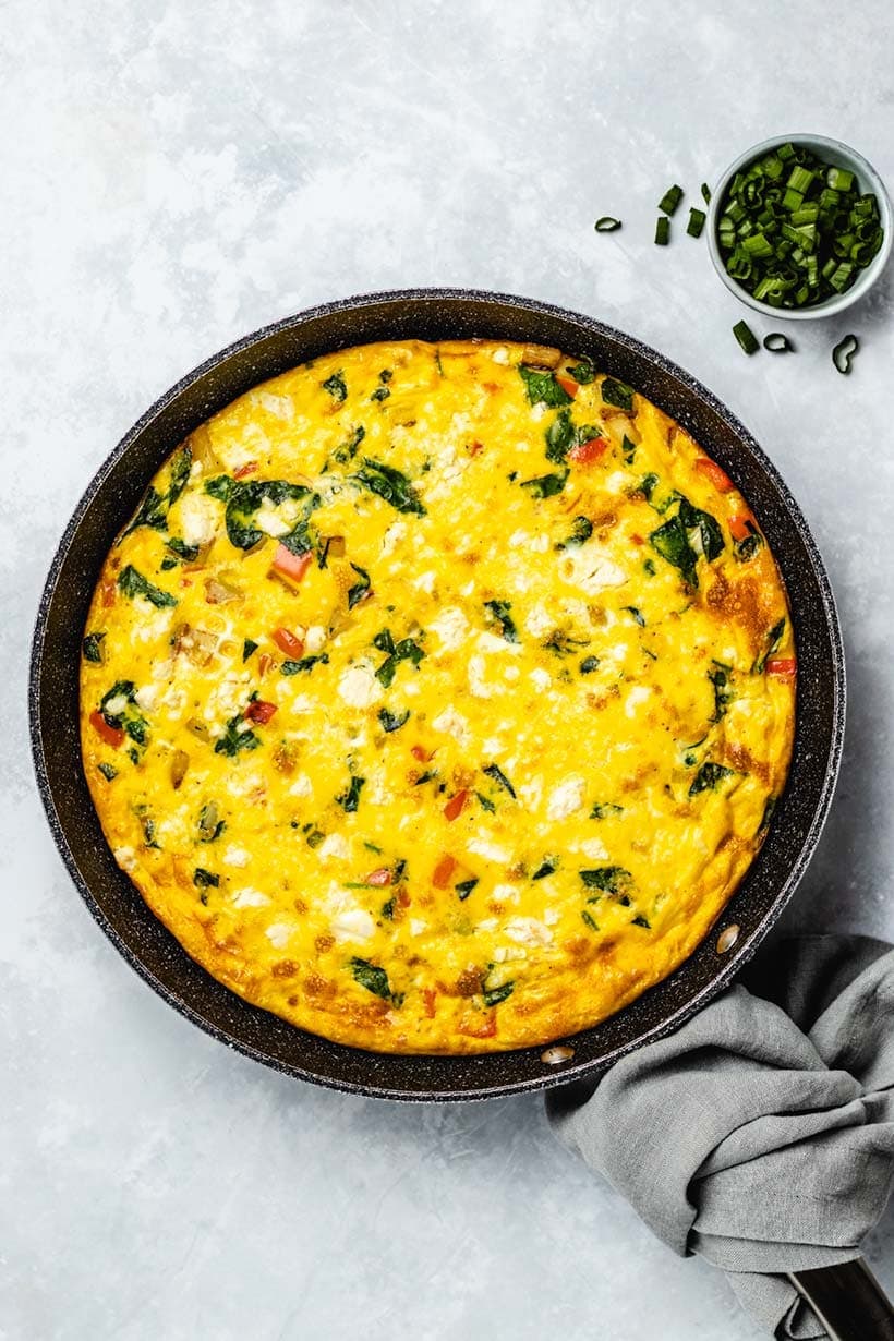 A frittata full of spinach, and potatos, and you can see some pieces of red pepper.