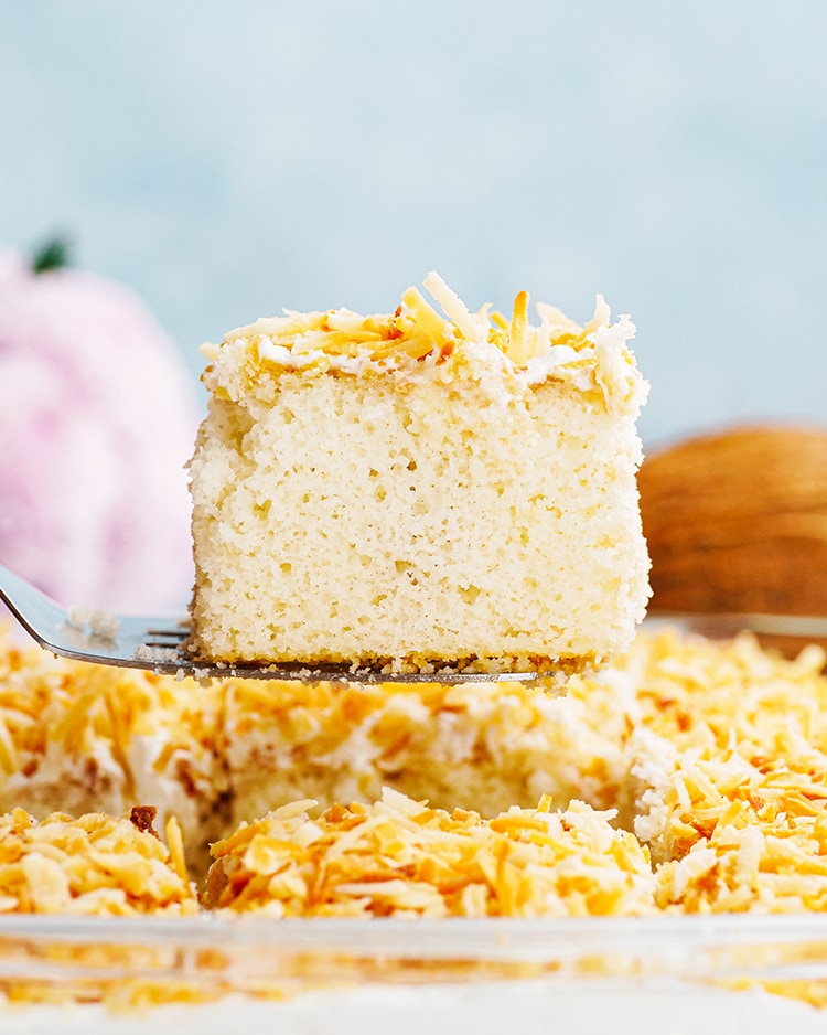 Coconut Cake being pulled out of a pan with a spatula