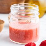A close up shot of a jar full of raspberry vinaigrette.
