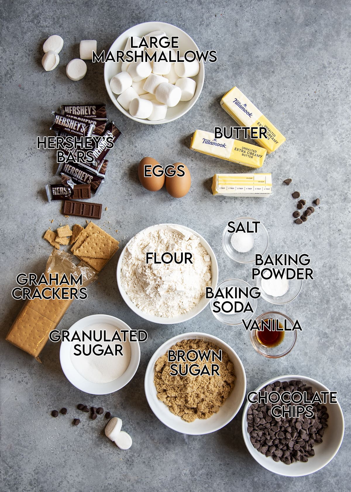 An overhead photo of the ingredients needed to make s'mores cookies with the name of the item over each thing.