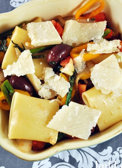 Top view of schiaffoni pasta with vegetables in a creme baking dish.