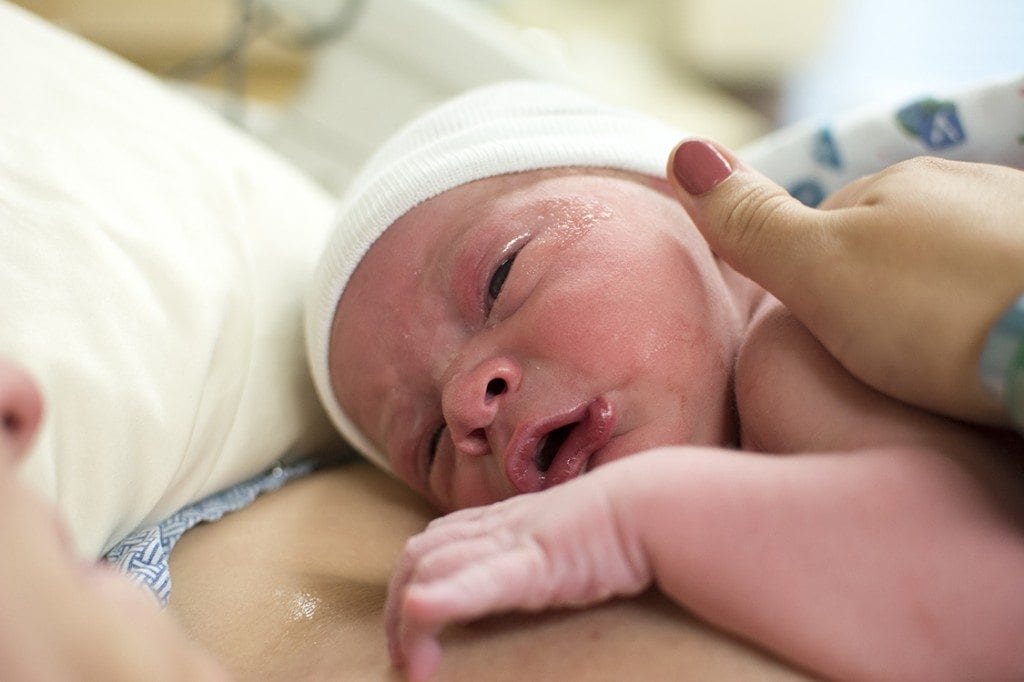 A newborn baby is crying shortly after birth.