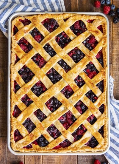 An overhead photo of a berry slab pie in a cookie sheet with a lattice crust on top.
