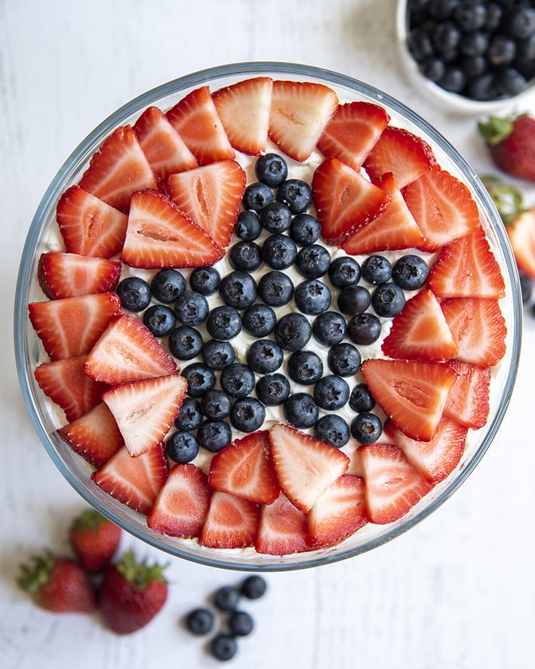 A star shaped out of blueberries with strawberries around it on top of a patriotic trifle