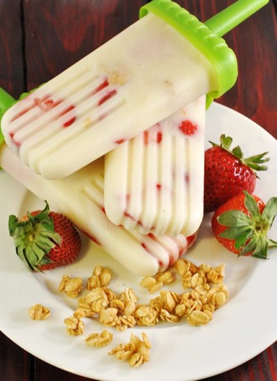 Angled view of strawberry granola yogurt pops on a plate.