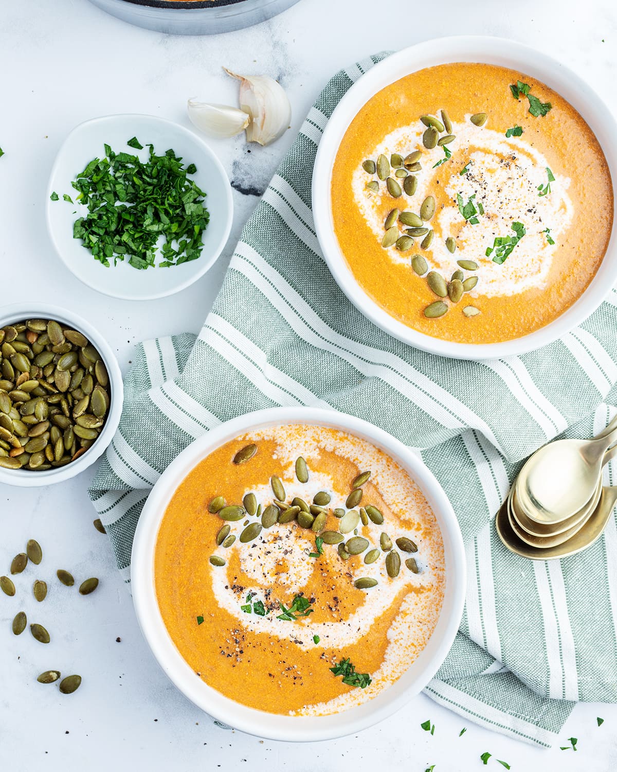 An overhead photo of two bowls of tomato squash soup. 