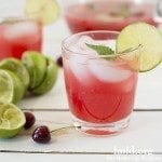 Front view of mint cherry limeade in a glass.