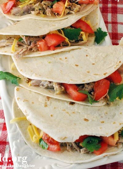 Top view of chili verde tacos on a square white plate.
