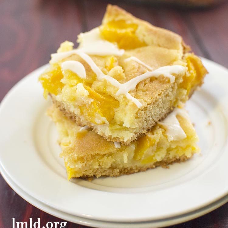 Angled view of peach cobbler bars on a white plate.