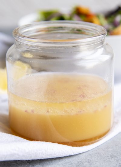 A wide mouth glass jar of lemon dijon dressing.