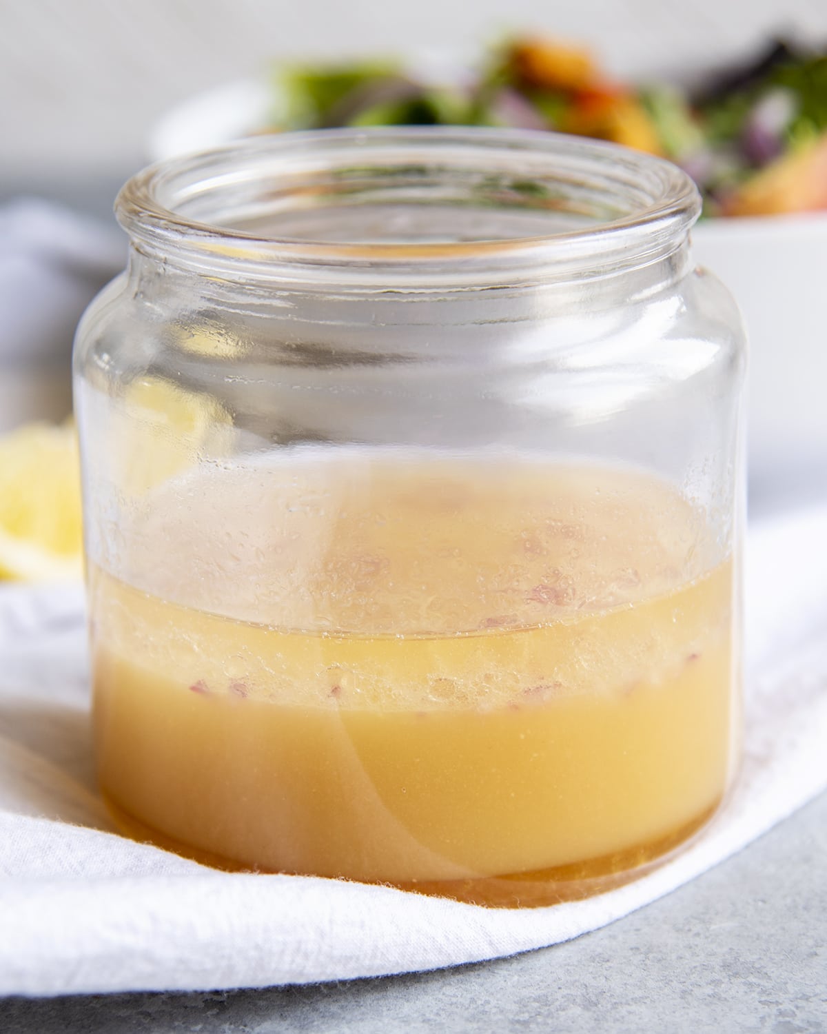 A wide mouth glass jar of lemon dijon dressing.