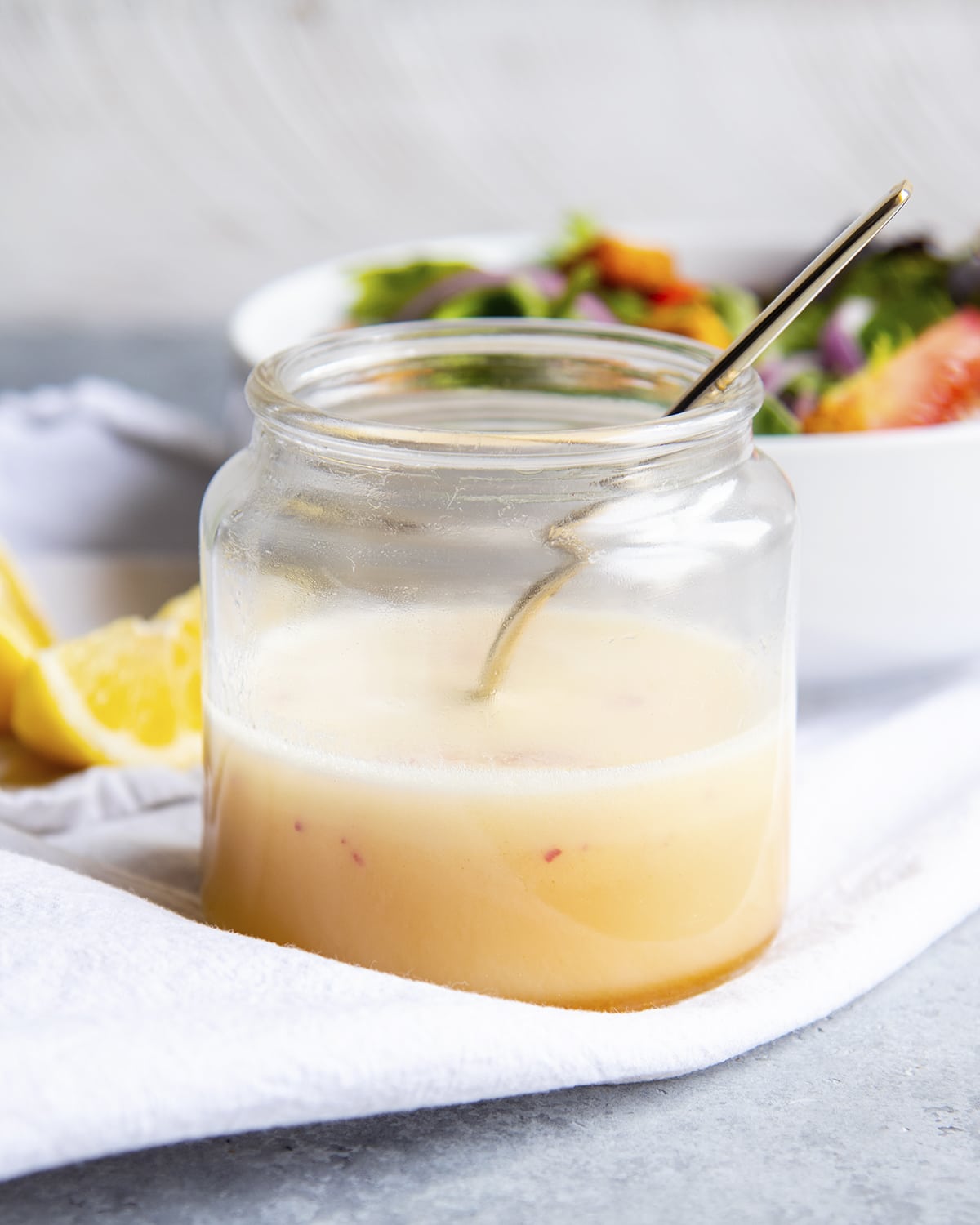 A glass jar of lemon salad dressing