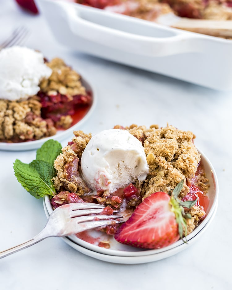 Strawberry Rhubarb Crumble topped with vanilla ice cream, and fresh mint