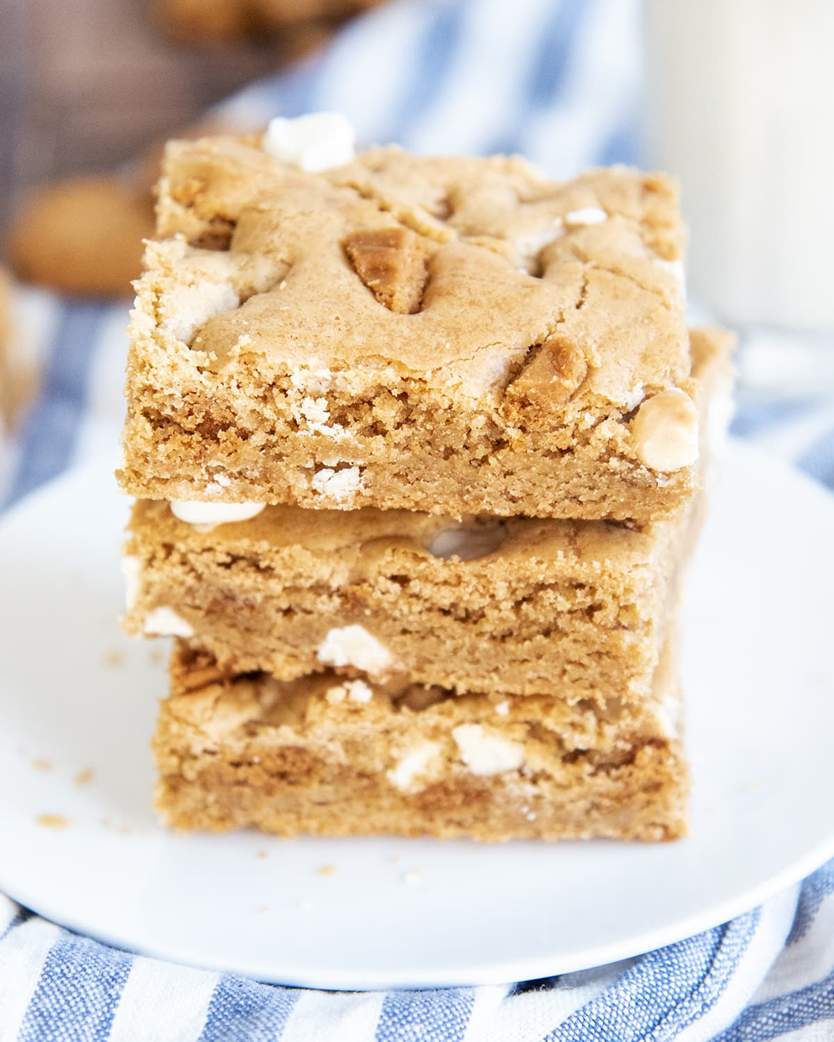 A stack of three blondie cookie bars full of chopped up Biscoff cookies and white chocolate chips.