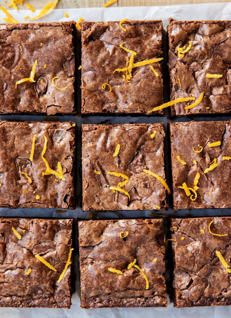 An above view of 9 squares of chocolate orange brownies in rows.