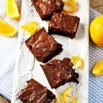 Top view of orange brownies on a white plate.