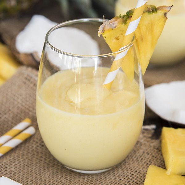 Front view of a pina colada smoothie inside of a glass.