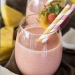 Front view of a strawberry pina colada smoothie in a glass.