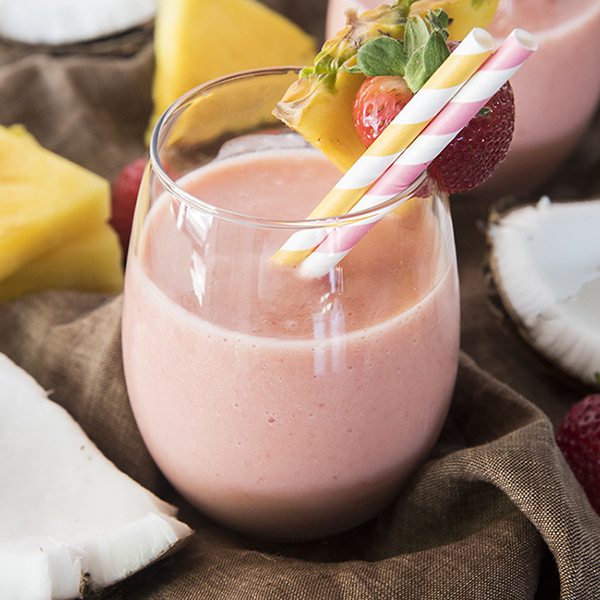 Front view of a strawberry pina colada smoothie in a glass.