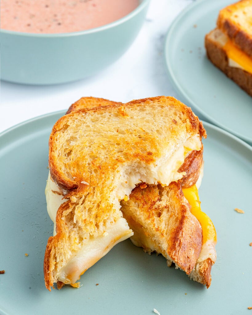 Two halves of a grilled cheese sandwich on a plate.