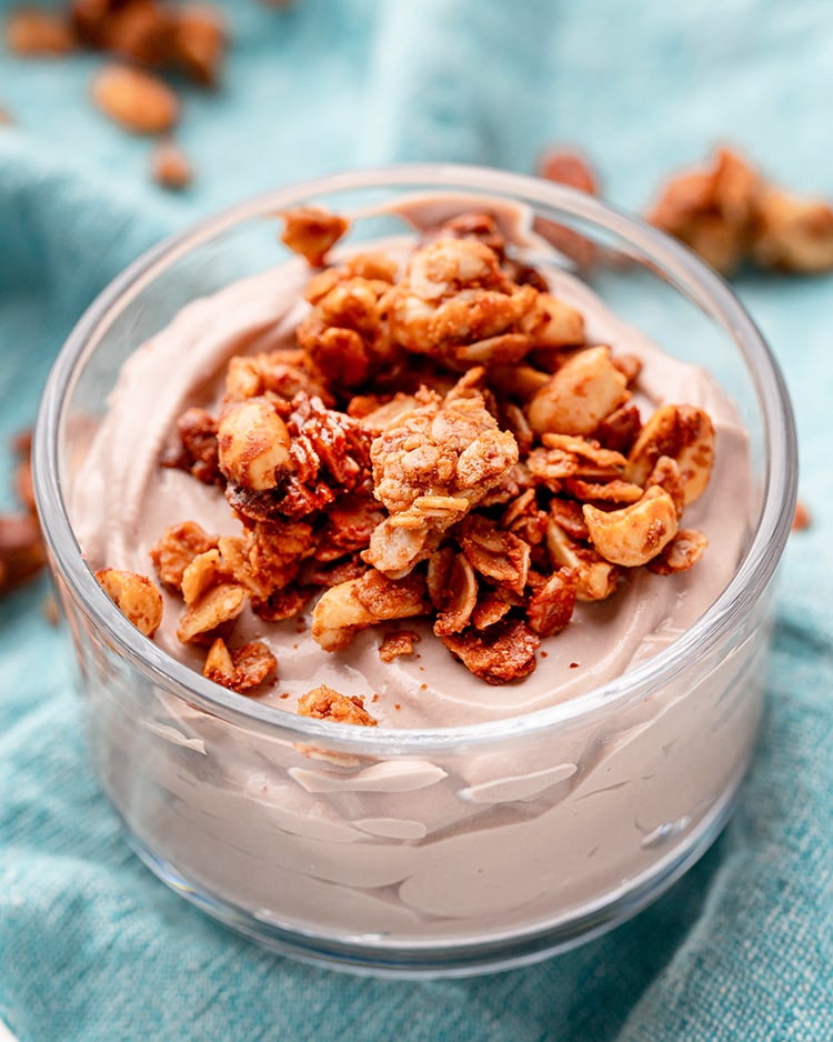 A bowl of yogurt topped with a sprinkle of peanut butter granola.