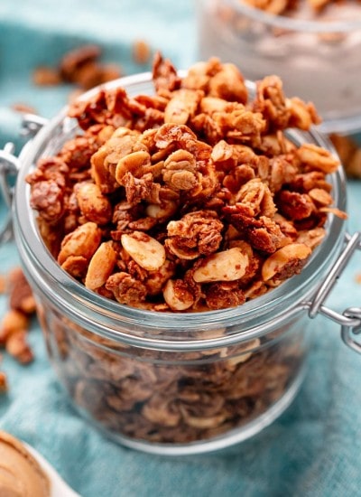 A jar of peanut butter oatmeal, it is a golden orange-ish color, with chopped peanuts.