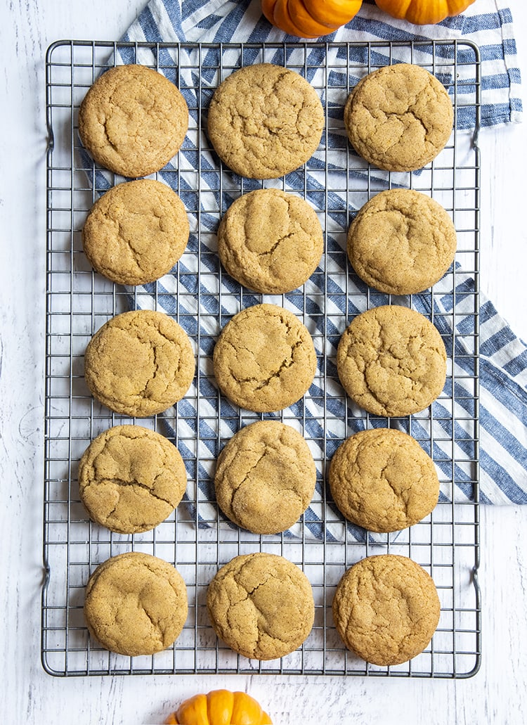 A cooling rack with pumpkin snickerdoodle cookies on it.