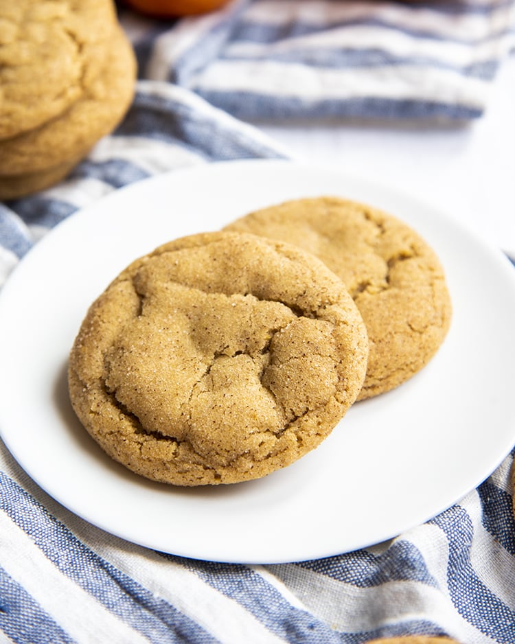 Two pumpkin spice snickerdoodles on a white plate.
