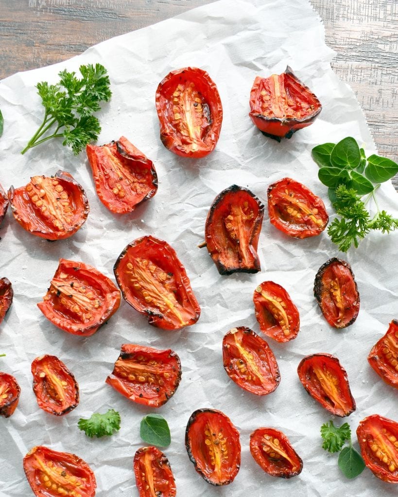 Above view of roasted tomatoes on parchment paper.