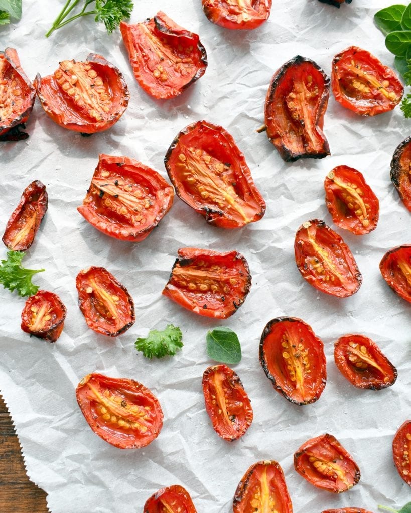 Top view of roasted tomatoes on parchment paper.