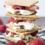 A stack of smores with white chocolate and fresh berries in them.