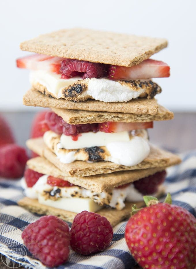 A stack of smores with white chocolate and fresh berries in them.