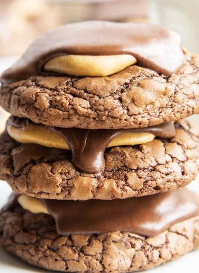 A square close up photo of a stack of three buckeye brownie cookies.