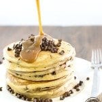 Front view of peanut butter chocolate chip pancakes with syrup on top.