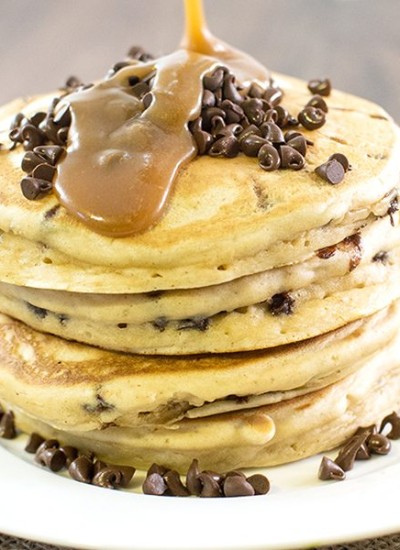 Front view of peanut butter chocolate chip pancakes with syrup on top.