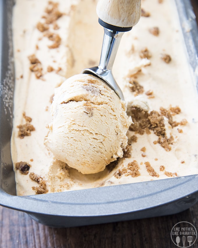 A scoop of pumpkin pie ice cream is rolled with an ice cream scoop.