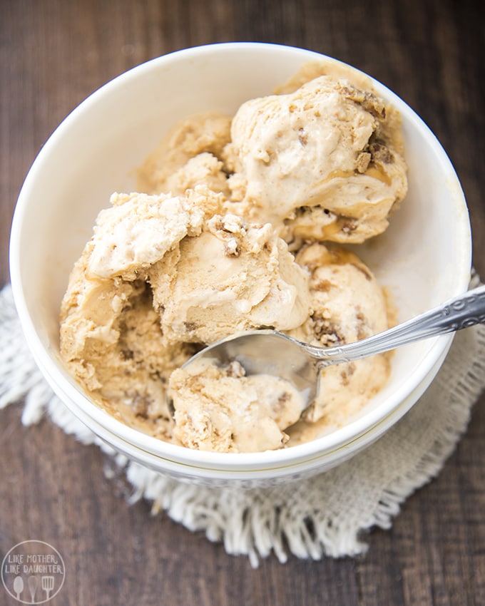 An overhead photo of a bowl of pumpkin pie ice cream with a spoon in the ice cream. 