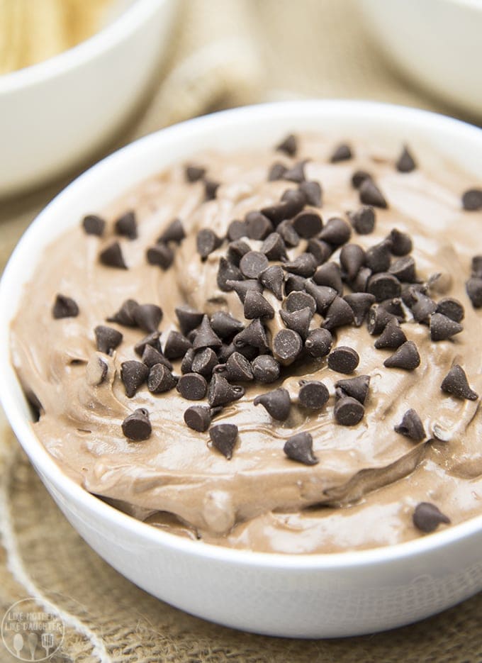 A bowl of brownie batter dip topped with mini chocolate chips.