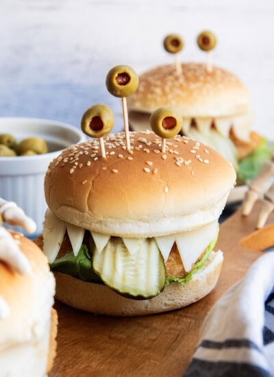 A chicken sandwich with three green olives on top to look like monster eyes.
