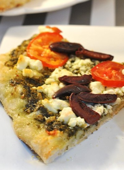 Angled view of a slice of mediterranean mini pizza.