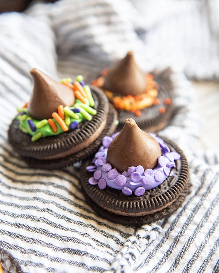 Three oreos topped with hershey\'s kisses and decorated to look like witch hats. 