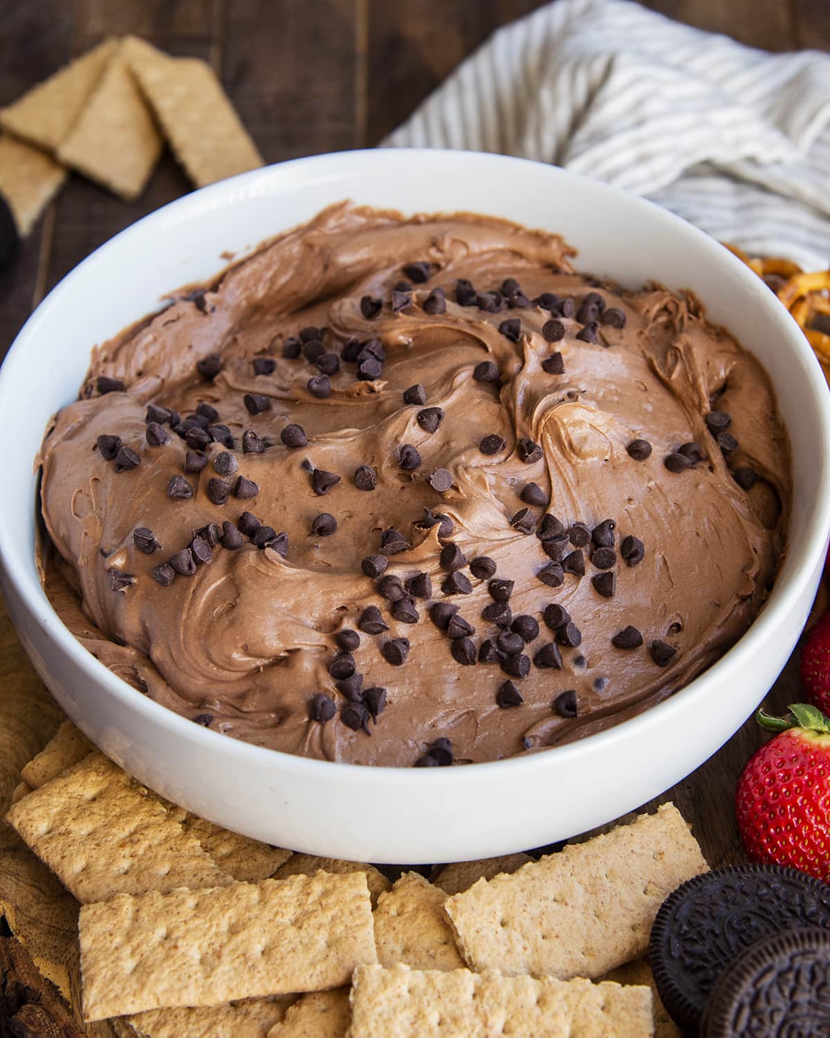 A bowl of brownie dip next to graham crackers. 