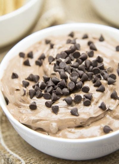 A bowl of brownie batter dip topped with mini chocolate chips.