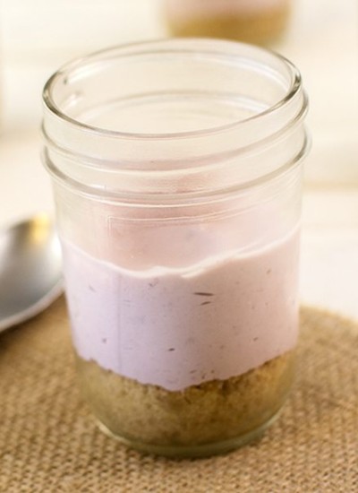 Front view of no bake berry cheesecake in a glass jar.