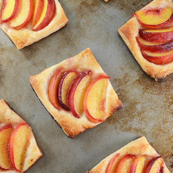 Top view of peach tart on a baking pan.