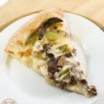 Top view of philly cheese steak pizza on a white plate.